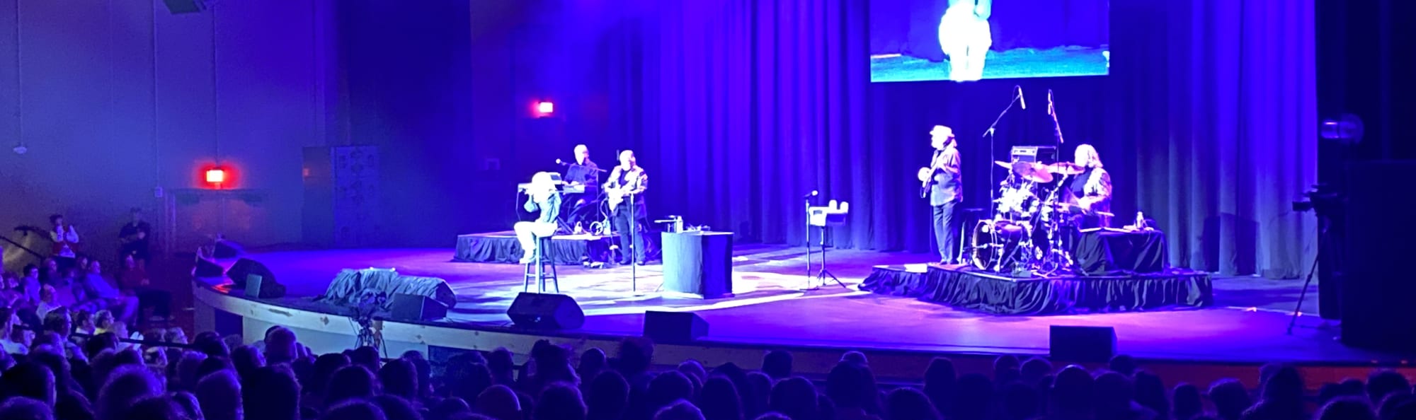 signer on stage in chair washed out by the lights Waco